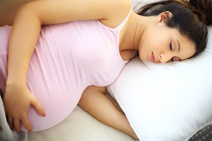 Femme enceinte dormant sur le côté