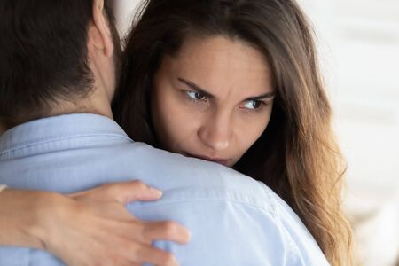 Jeune femme pensive embrassant son partenaire après une dispute