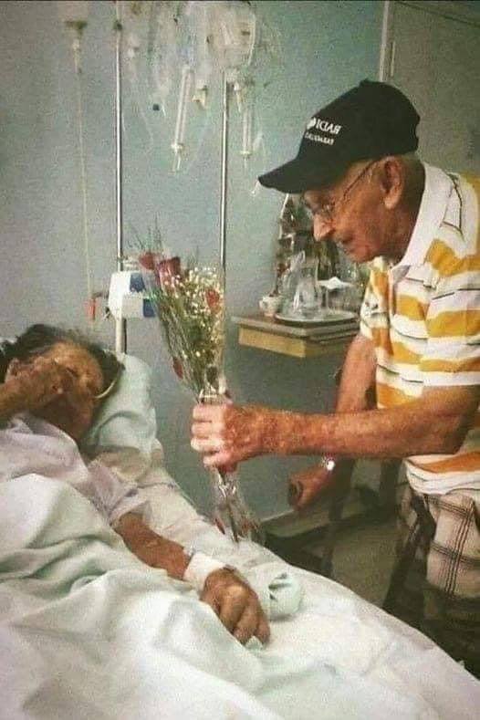 Homme âgé souriant tenant une photo de couple