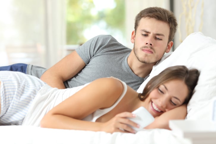 Homme jaloux observant son téléphone