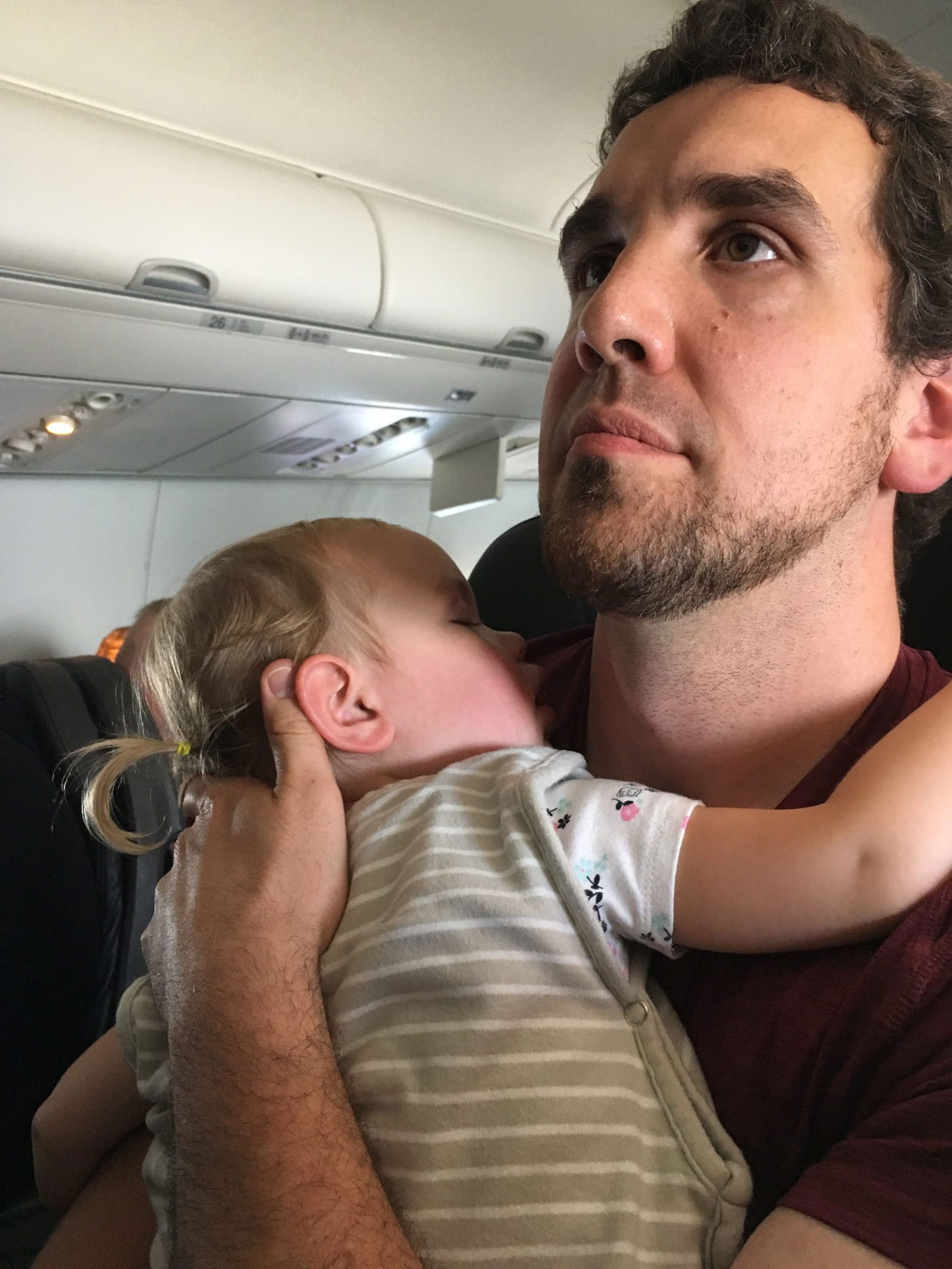 Homme berçant un bébé dans un avion