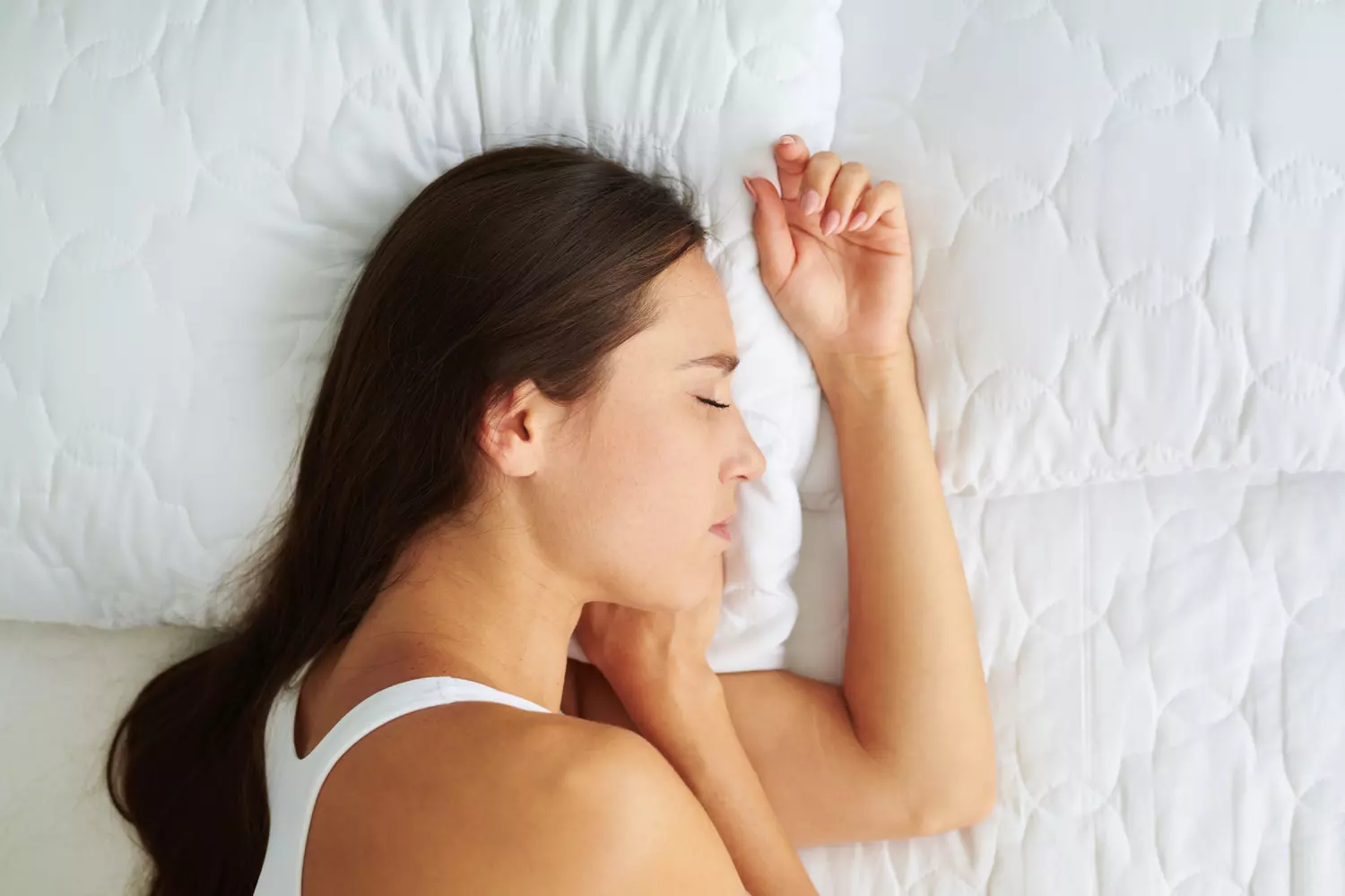 Personne dormant en position fœtale sur le côté avec coussin entre les genoux