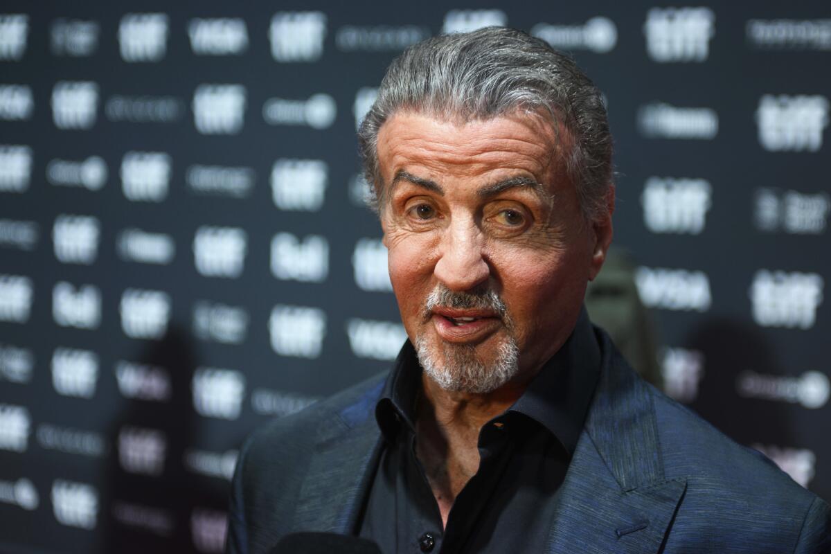 Stallone souriant, visage marqué par la vie