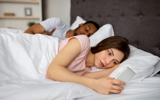 Femme regardant son téléphone avec méfiance