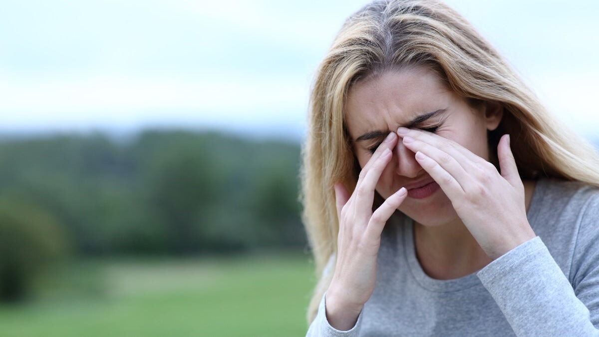 Jeune femme se frottant les yeux avec inconfort