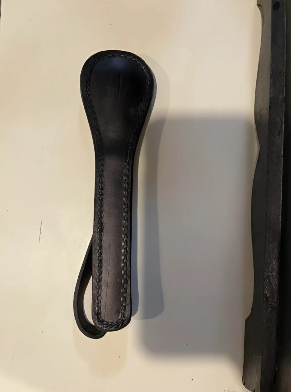 Petit objet en cuir matelassé tenu à la main