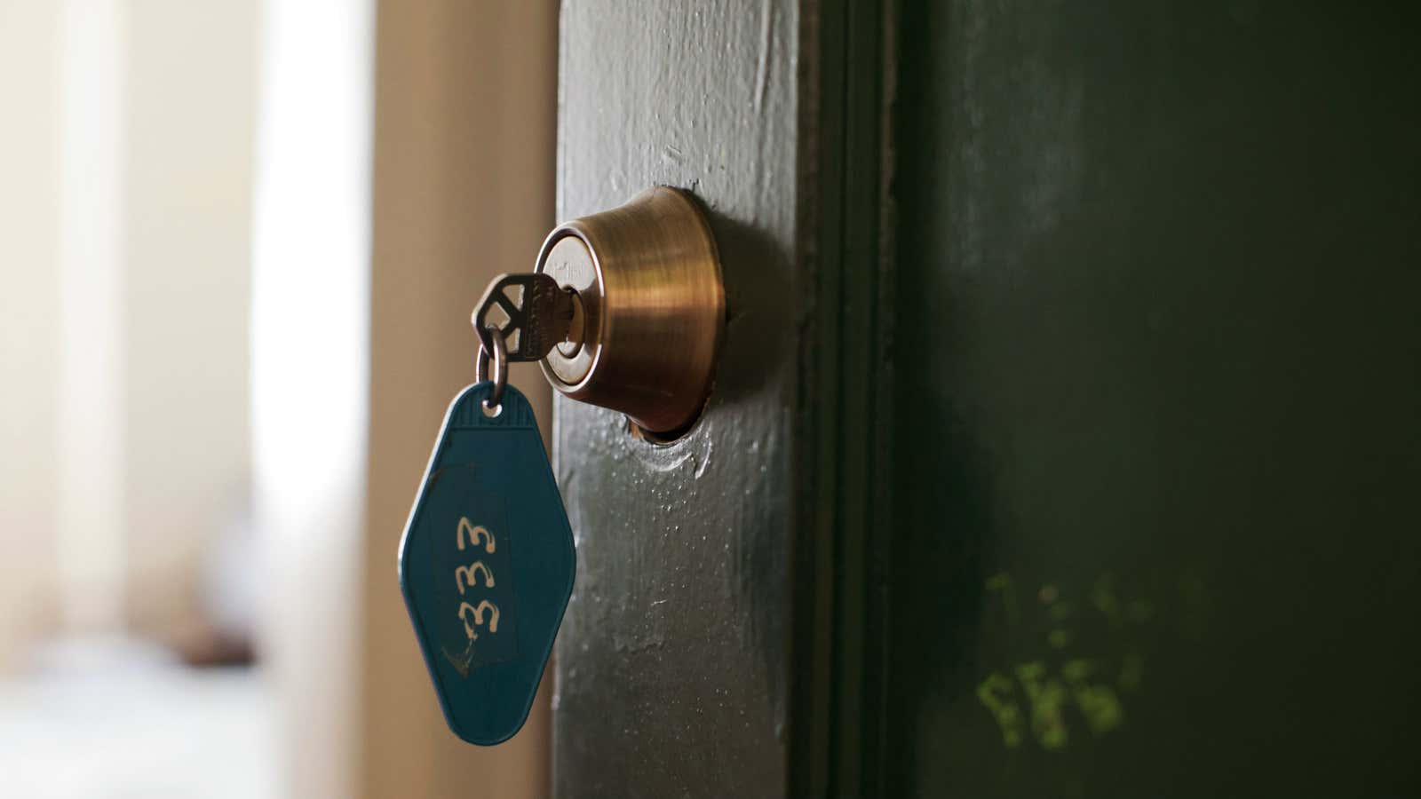 Clé insérée dans une serrure avec une habitation éclairée de nuit en arrière-plan