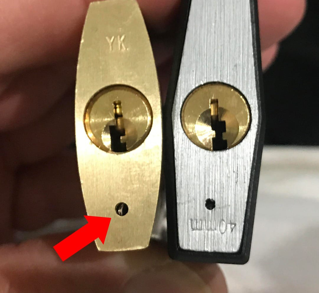 Détail rapproché montrant le petit trou d'évacuation sur le corps d'un cadenas