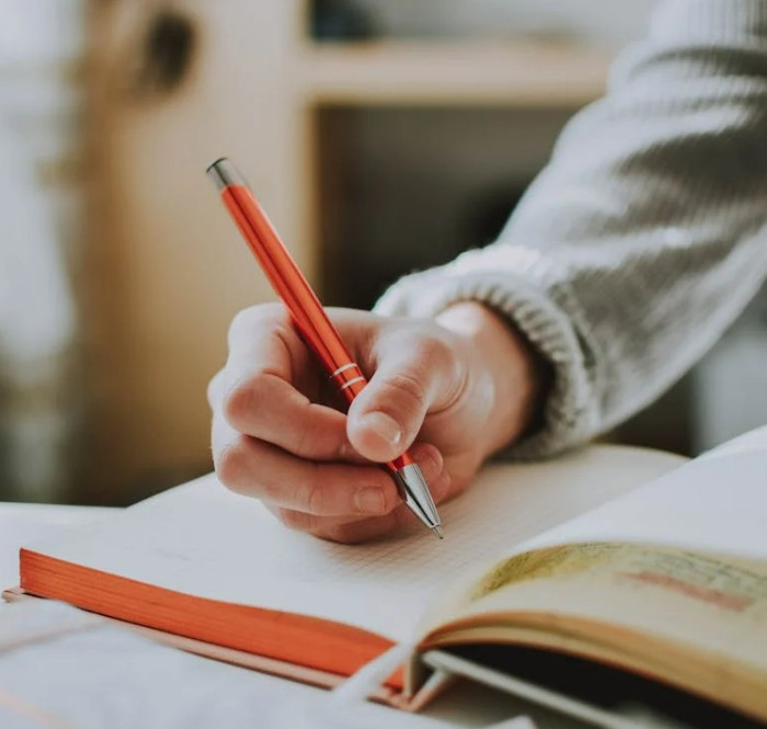 Main gauche écrivant, illustrant l'héritage de la gaucherie