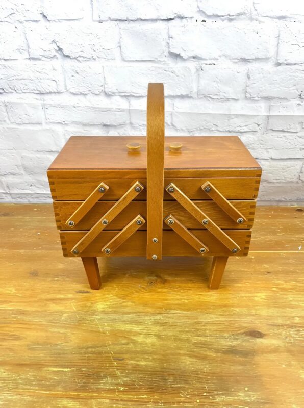 Grand-mère tenant la boîte de couture, émue