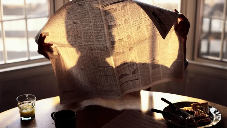 Deux mains féminines tenant une vieille photo et un document, symbolisant la découverte d'un secret de famille.