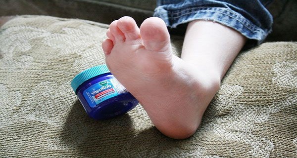 Personne appliquant du Vicks VapoRub sur son pied avant de dormir