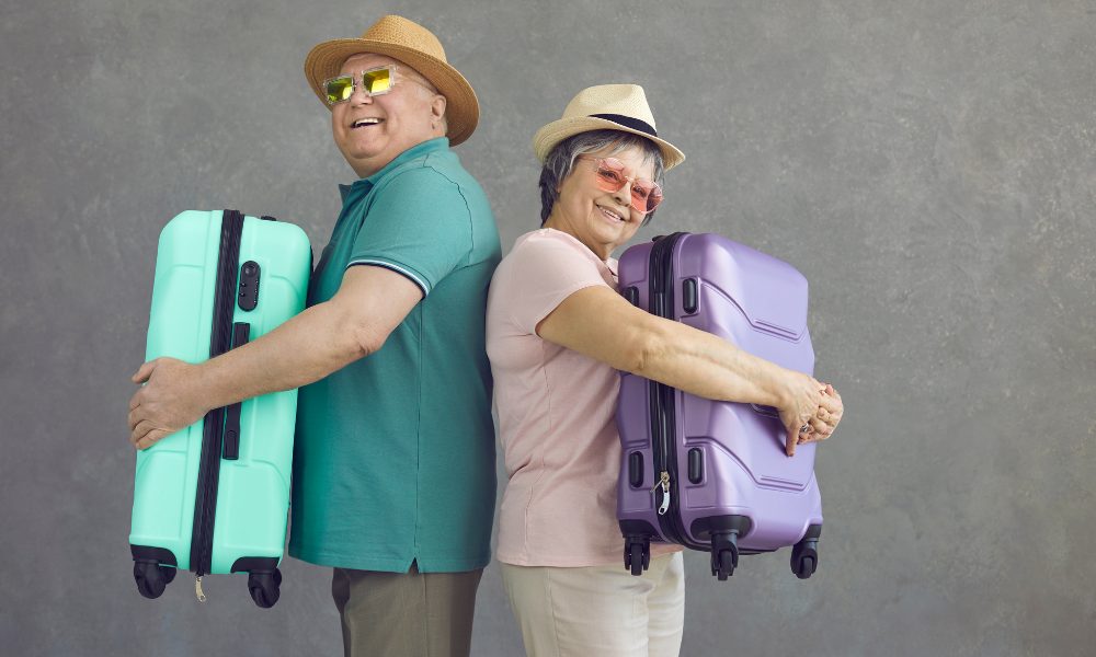 Un couple de seniors souriant, profitant d'une vue panoramique lors d'un voyage, symbolisant la sérénité.