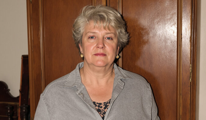 Une vieille photographie en noir et blanc d'un intérieur familial, posée sur une table en bois.