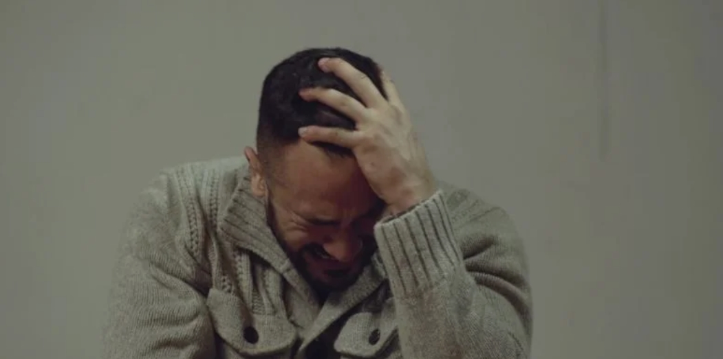 Lucas, adolescent en tenue de sport, serre dans ses bras Thomas, émotionnés, lors d'une cérémonie publique. Une médaille est visible.