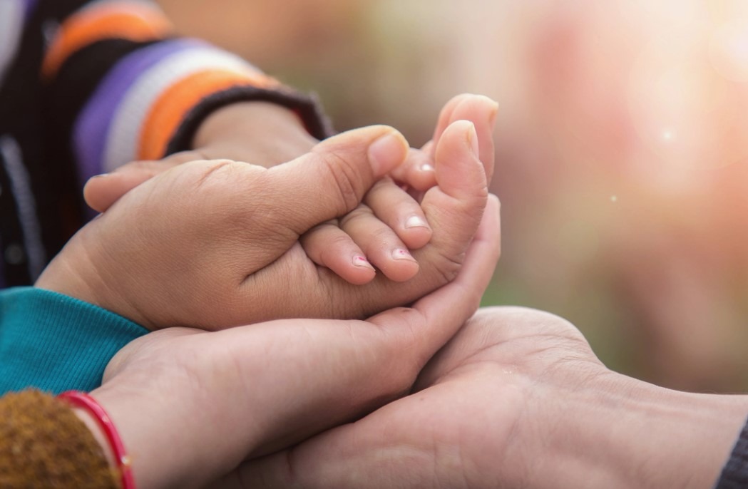 Un père et son fils, souriants, jouant ensemble par terre avec des jouets.