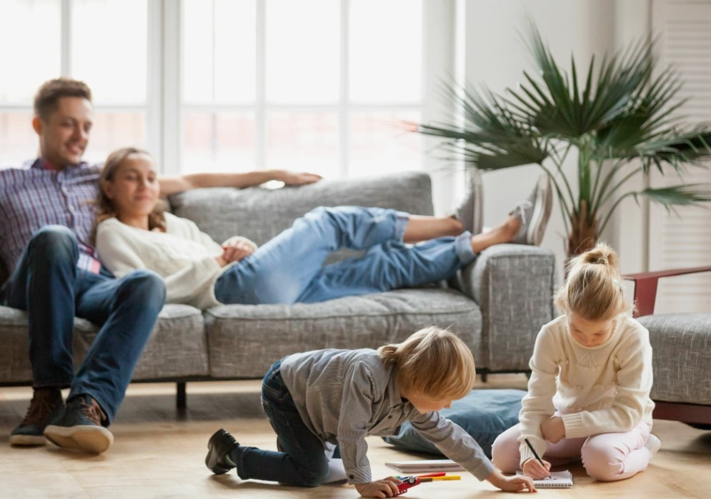 Un adolescent souriant, encadré par un homme et une femme fiers, le jour d'une cérémonie.