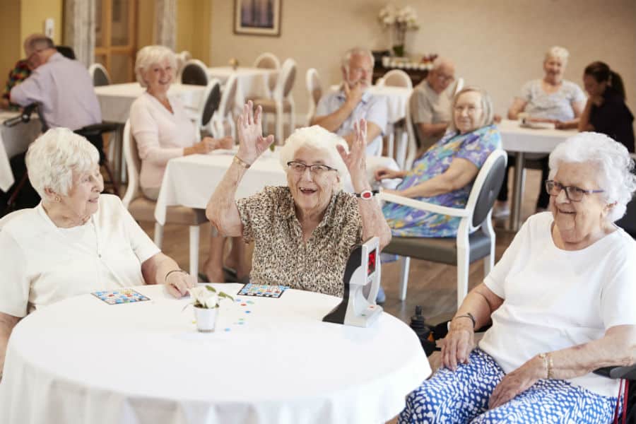 Un animateur encadrant un groupe de résidents lors d'une activité physique douce en salle.