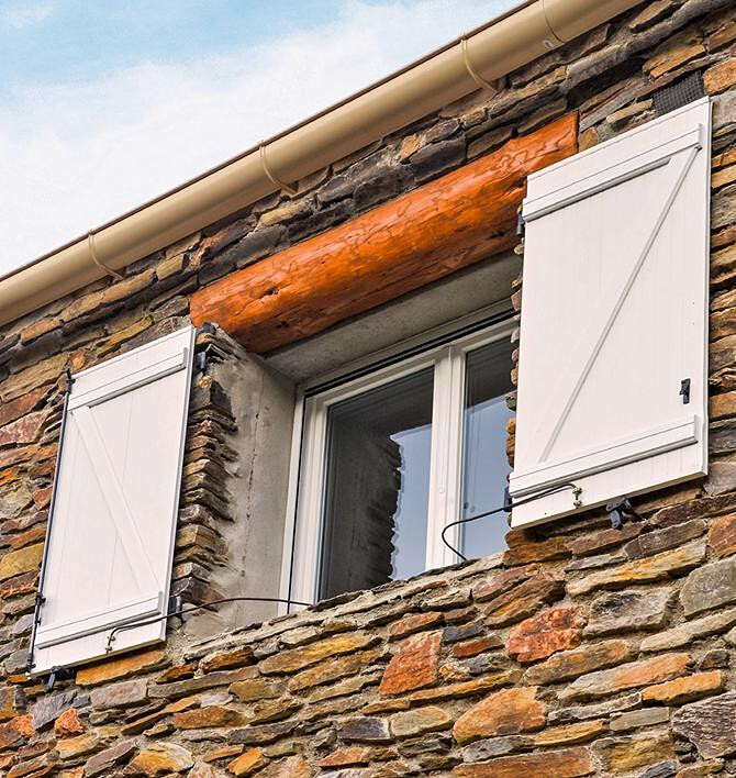 Main ouvrant un volet pour laisser entrer la lumière du jour