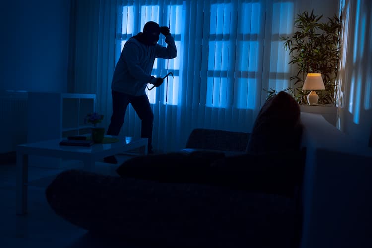 Photo représentant une porte d'entrée endommagée par une effraction, avec un agent d'assurance prenant des notes.