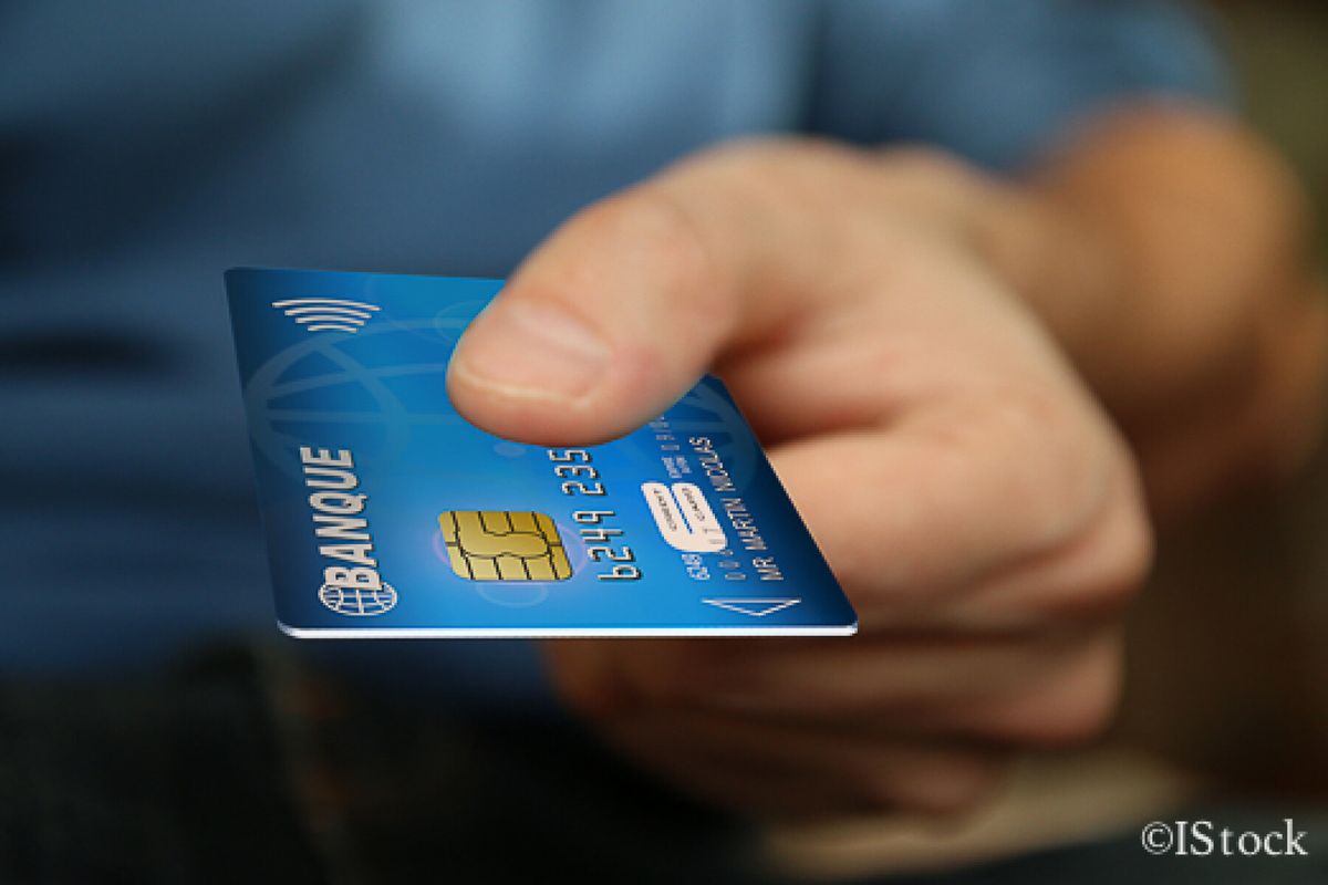 Gros plan sur une carte bancaire tenue dans une main.