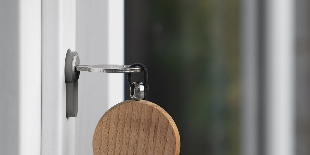 Une main tenant une clé ancienne devant une porte entrouverte, métaphore du choix et des nouvelles opportunités.