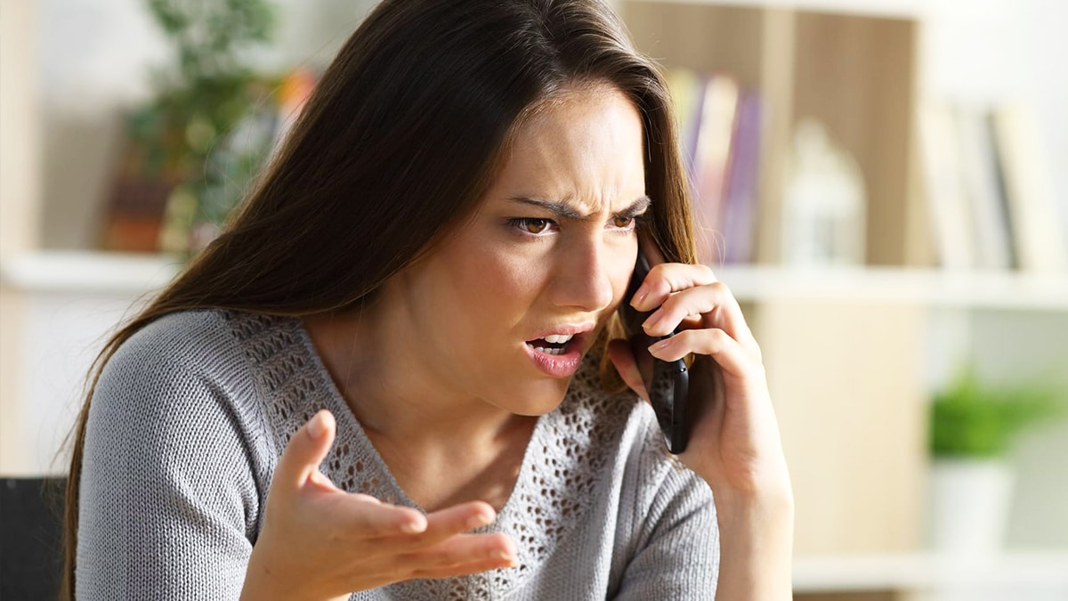 Une femme sourit calmement au téléphone, en contrôle de la situation