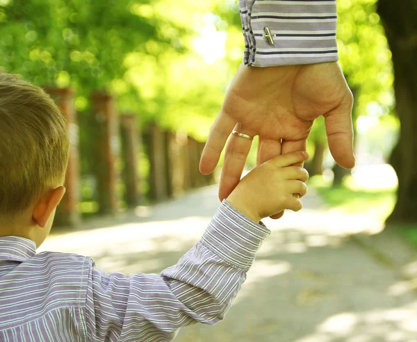 Parent tenant la main d'un enfant, symbole de famille et de complicité