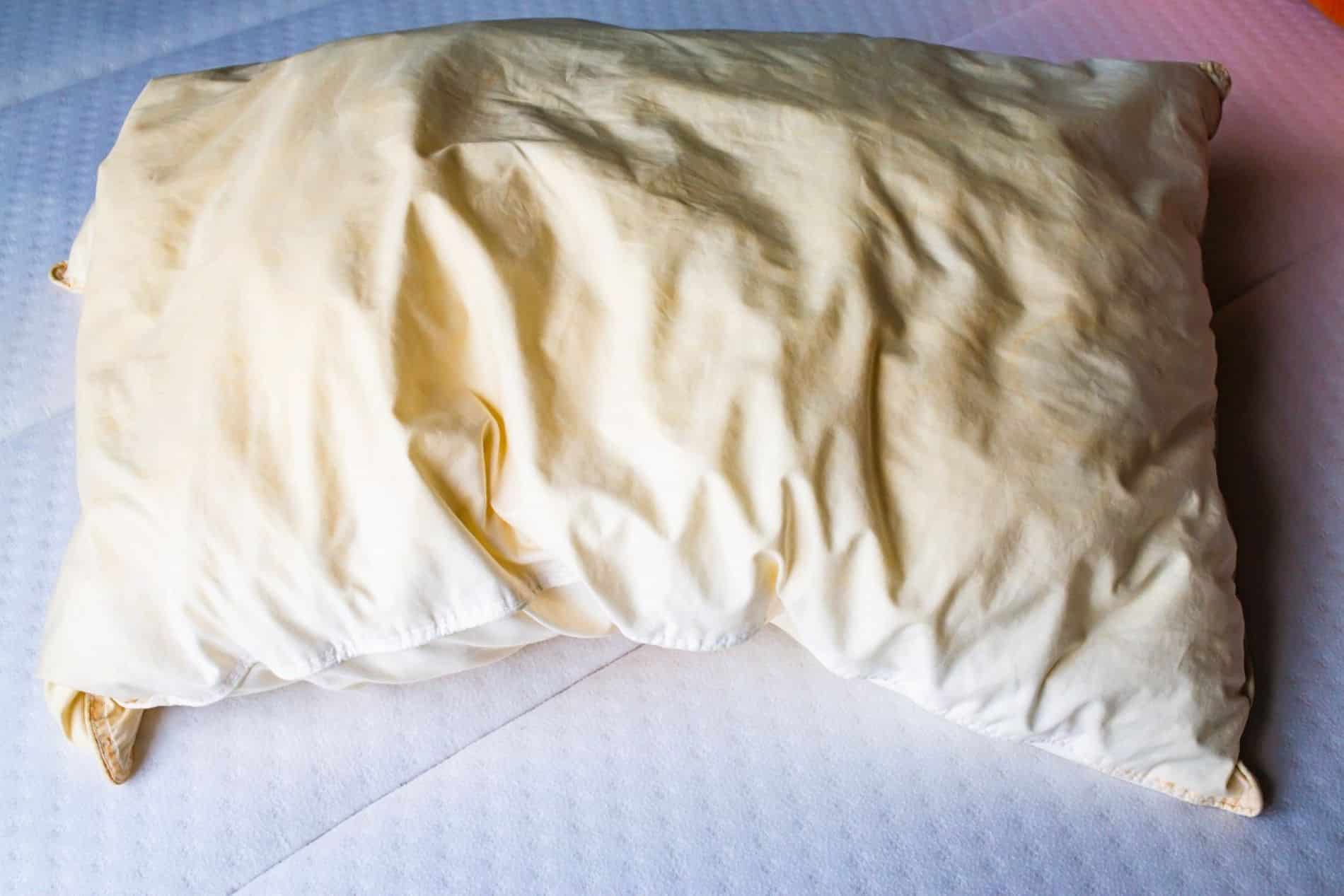 Oreiller blanc présentant des taches jaunâtres