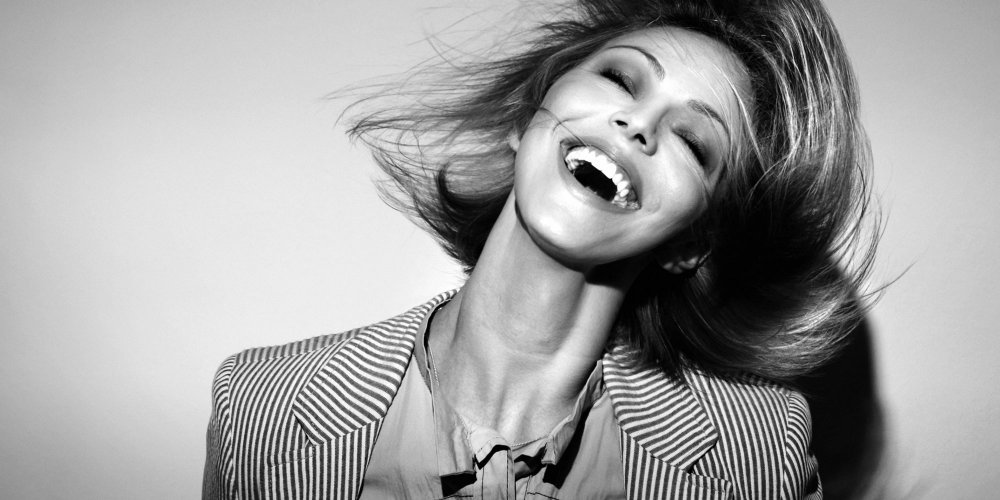 Jeune femme riant, illustrant les bienfaits du rire