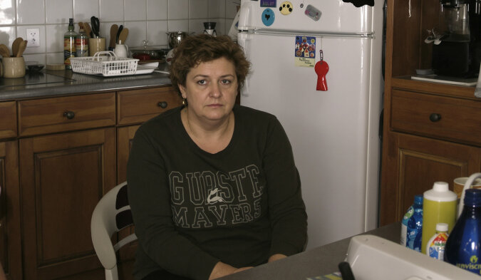 Femme pensive regardant par la fenêtre, illustrant une réflexion profonde