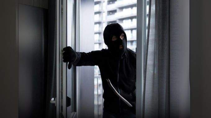 Illustration d'une personne surprise par une intrusion nocturne dans son salon, évoquant la confusion et la peur.